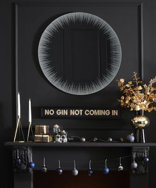A living room with black wall decor, round mirror and 'No gin, not coming in' wall plaque