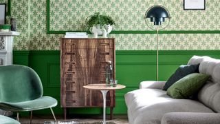 living room with green wall panelling and patterned green wallpaper