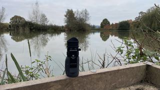 The Vortex Solo R/T 8x36 Monocular standing on end in front of a lake.