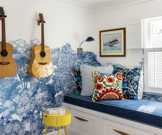 window seat with blue floral wall art and guitars on wall