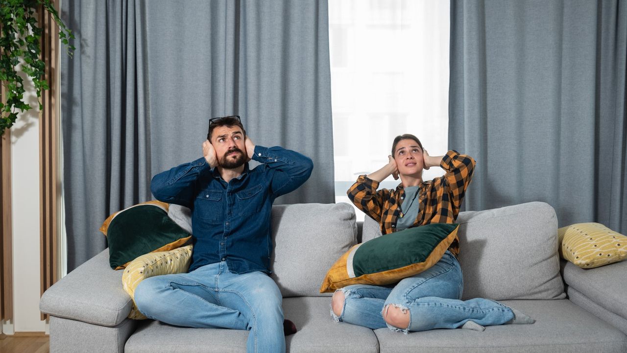 couple covering their ears to block out outdoor noise