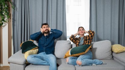 couple covering their ears to block out outdoor noise