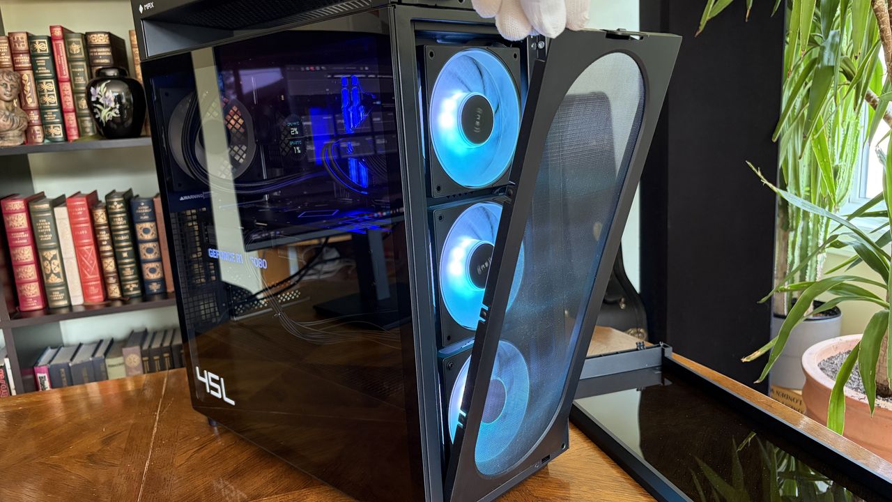 An Omen Max 45L computer tower with a transparent side panel showcases illuminated cooling fans. It is placed on a wooden surface near a bookshelf and indoor plants.