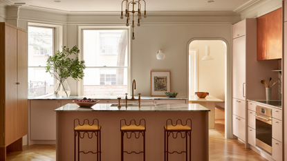 large period kitchen with curved metal stools and dusty pink cabinets