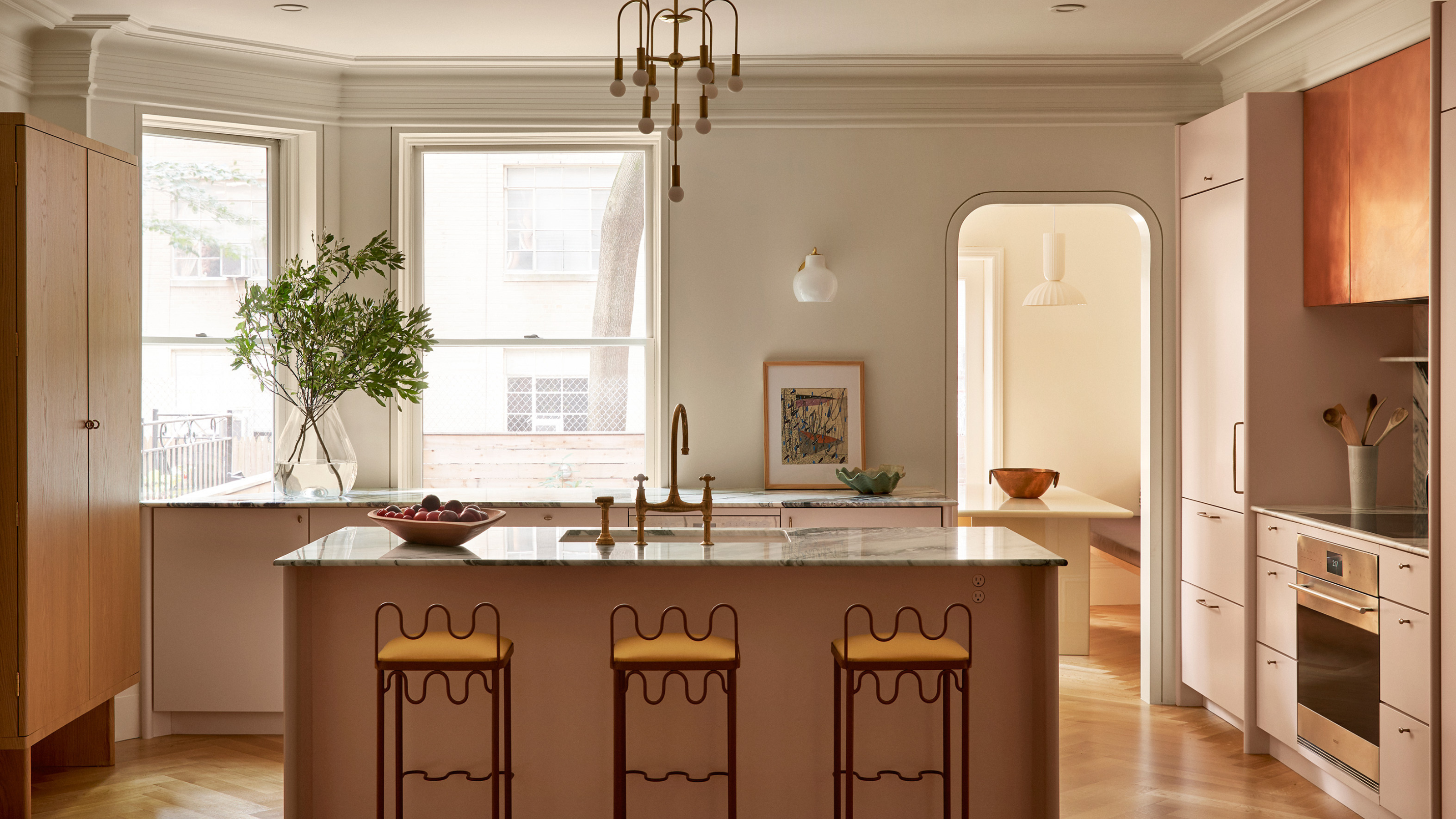 large period kitchen with curved metal stools and dusty pink cabinets