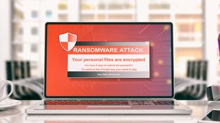 A ransomware splash screen displayed on a laptop in an office
