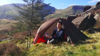 Man sitting in tent porch