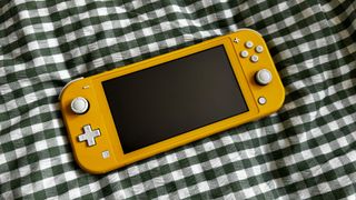 Yellow Nintendo Switch Lite on a plaid blanket