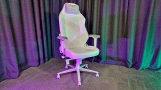 The Secretlab Titan Evo NanoGen Edition chair on a grey floor with grey curtains behind it