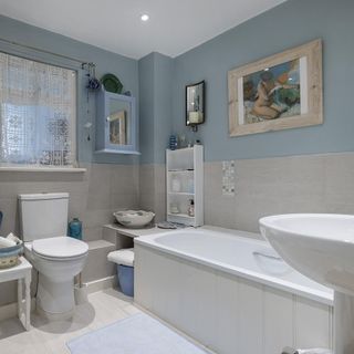 bathroom with white bathtub and blue wall