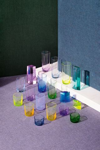 Several thin glasses of different sizes, colours include yellow, lilac, green, blue and pink