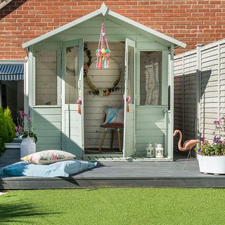 garden area with green shed and plants