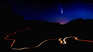 Comet C/2022 E3 (ZTF) over the road in the mountains at nigh