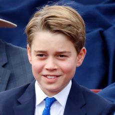 Prince George smiling in a blue suit and tie