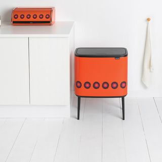 orange touch bin on white flooring