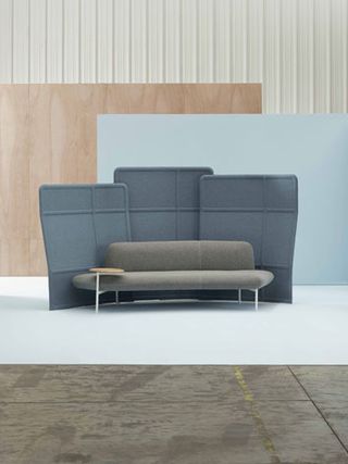 Grey scale sofas with fabric backs that create a cocoon effect and a reliance on soft textiles