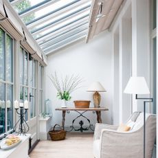 Lean-to conservatory with wooden floors, neutral blinds and layered lighting