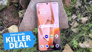 OnePlus 13R leaning against a rock with a Killer Deal tag