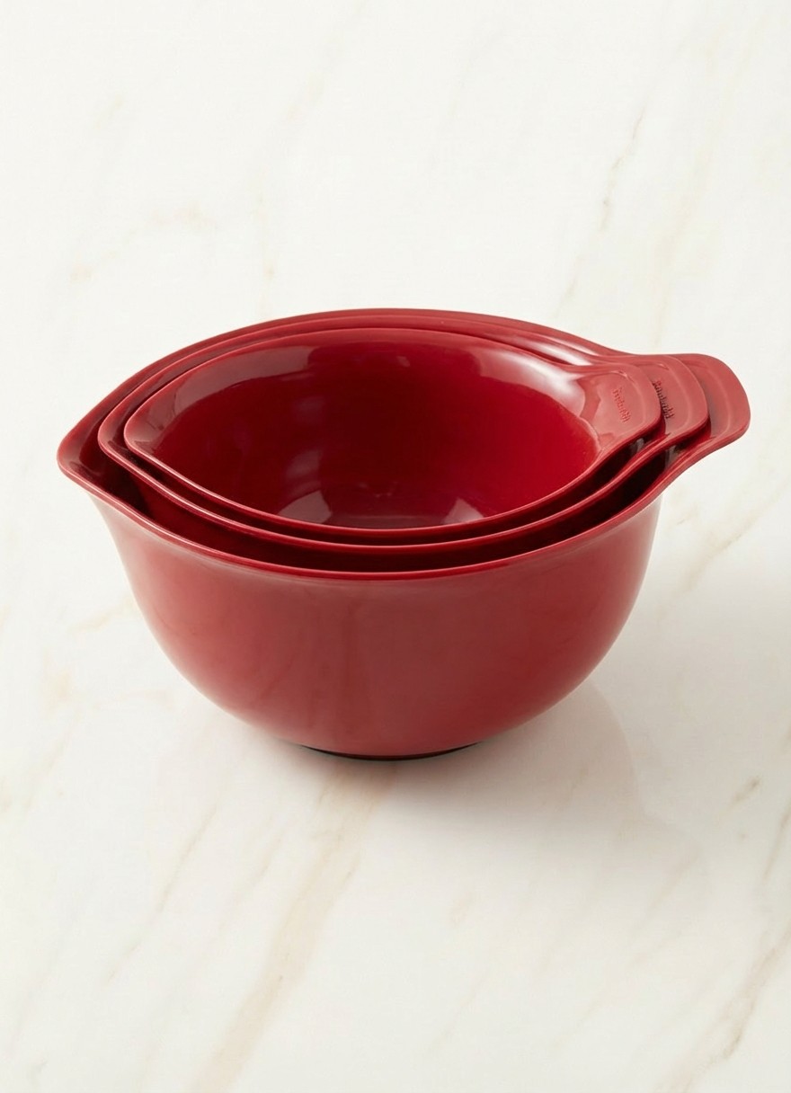 Red KitchenAid accessory on cream marble background