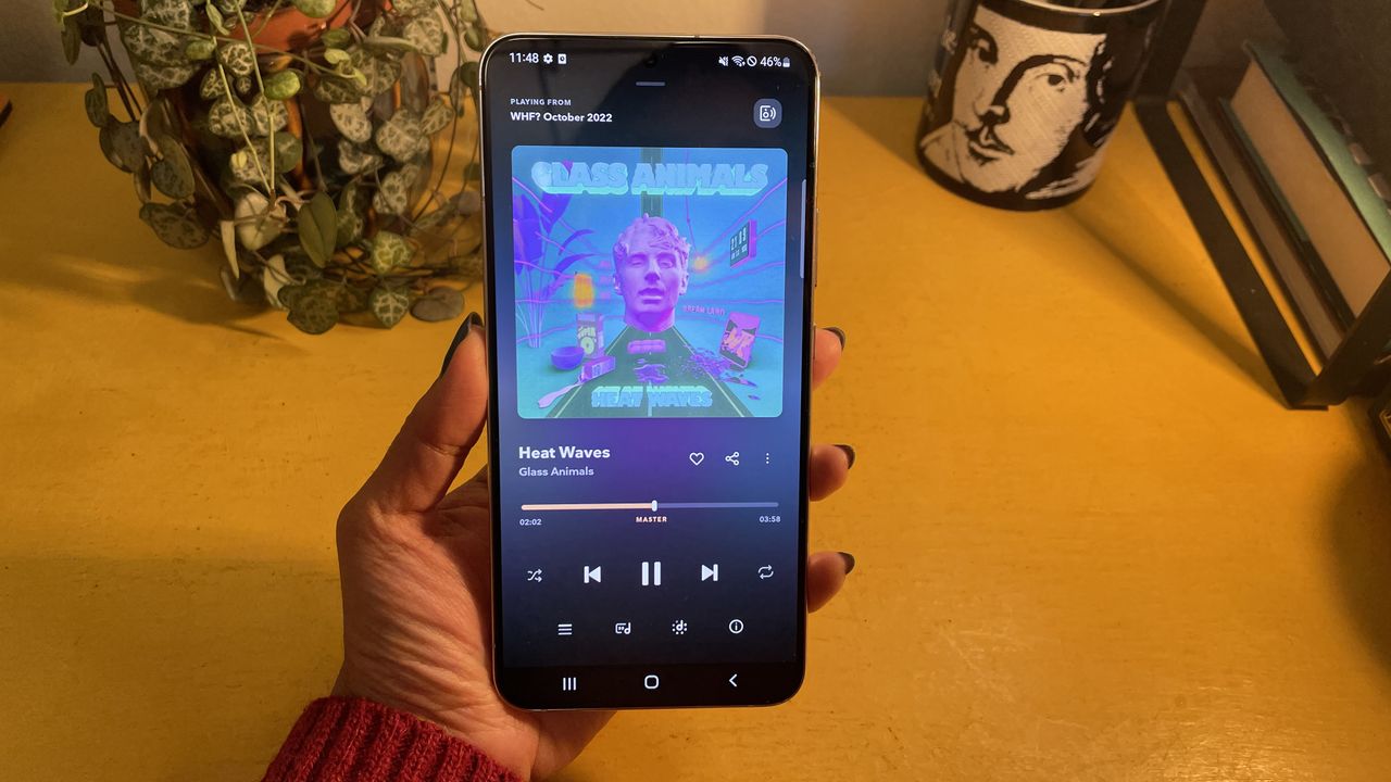 A hand holding a Samsung Galaxy S22 Plus smartphone. The Tidal app is open on the screen.