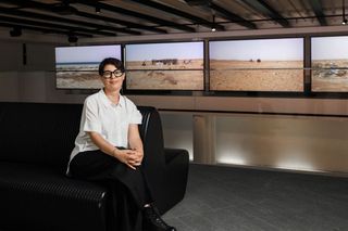 Nicène Kossentini in front of her video installation Landscapes at Louvre Abu Dhabi