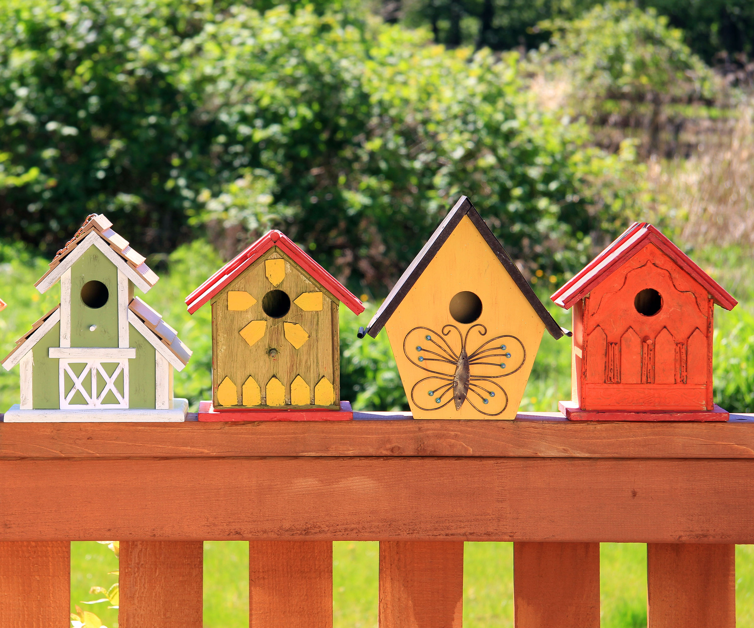 colorful bird house arrangement on garden bench