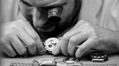 A professional inspecting a luxury watch