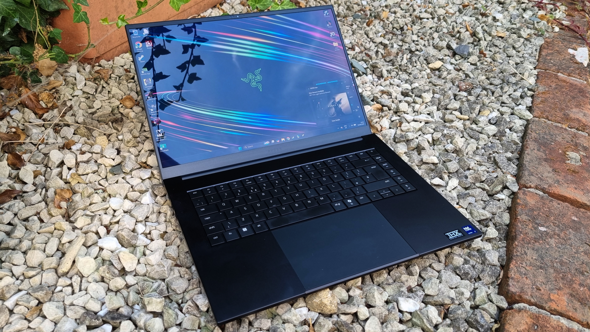 A Razer Blade 16 gaming laptop outside on white gravel