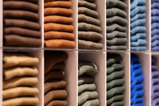 Getty Image of stacks of identical sweaters in different colours folded neatly on shelves