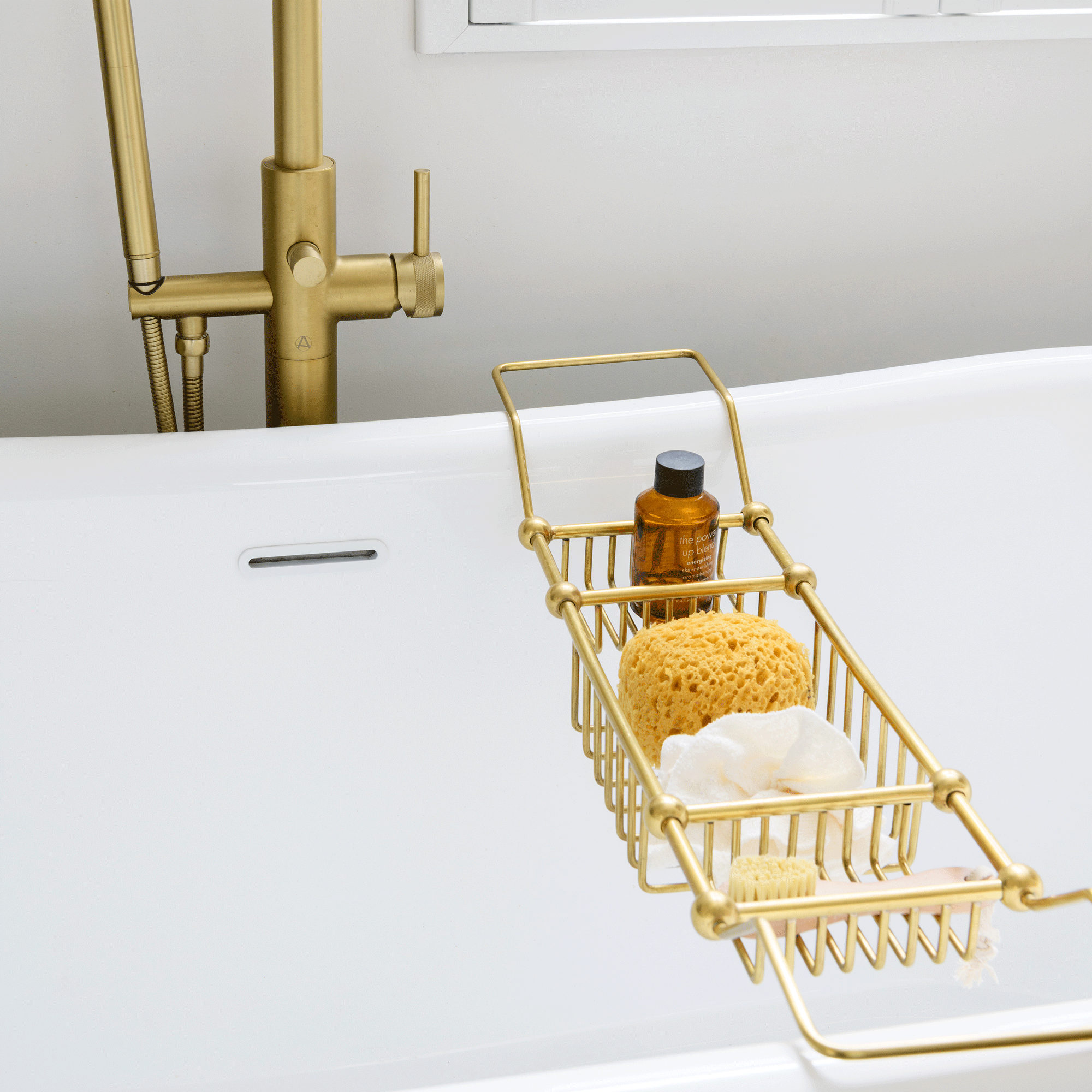 white bath tub with brass bath caddy and matching brass tap