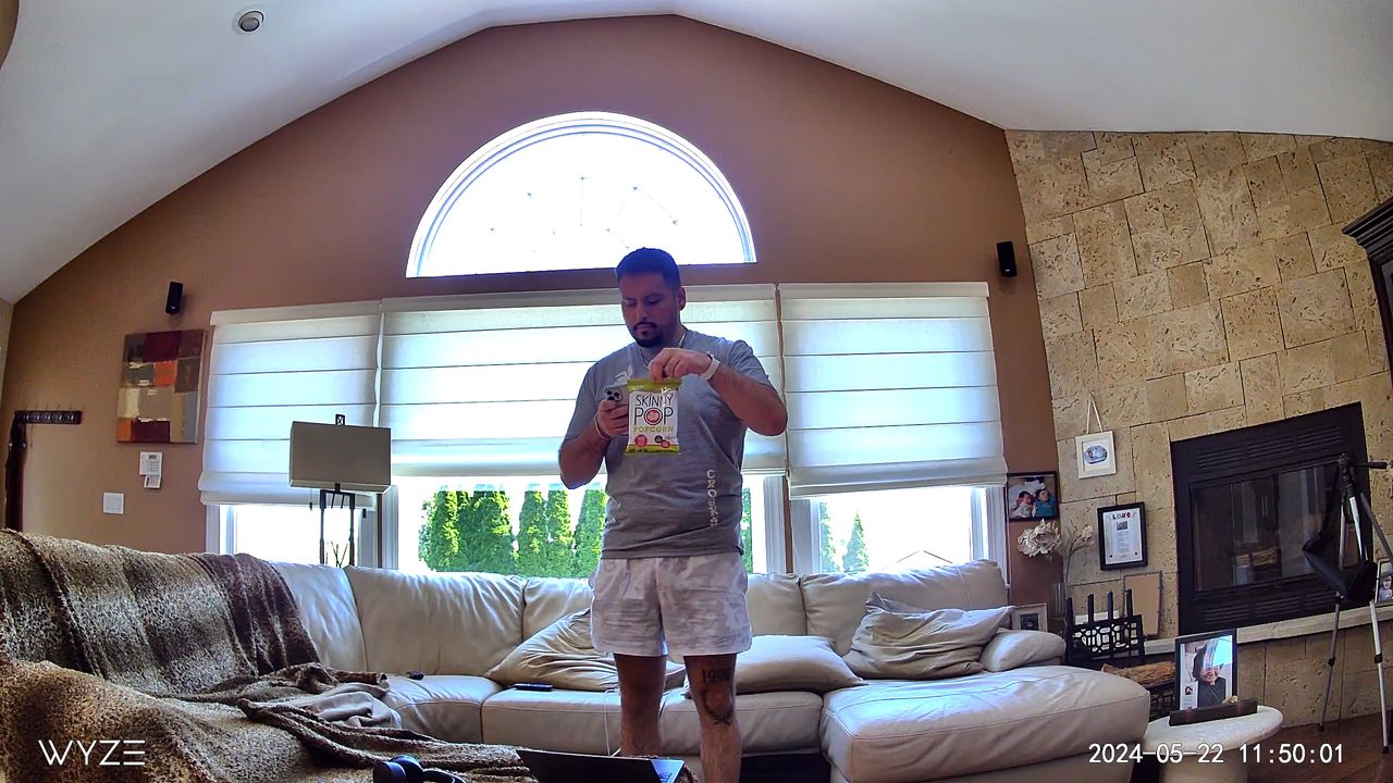 Wyze Cam v4 captures man holding popcorn in living room during the day