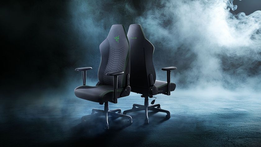 A Razer Iskur V2 X marketing reveal image of two chairs back-to-back in front of a smoky scene