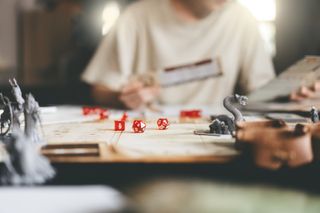 A person plays a role playing board game like Dungeons and Dragons