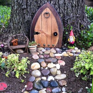 garden is made using arched door pebble path and mini potted plants