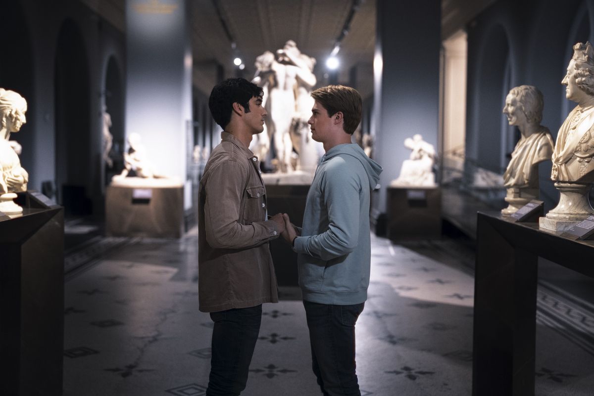 A scene from Red, White &amp; Royal Blue showing Alex (Taylor Zakhar Perez) and Henry (Nicholas Galitzine) holding hands in the V&amp;A Museum after-hours