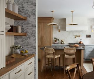 A tile inspired wallpaper on the walls on a coffee nook paired with off white cabinetry and wooden countertops