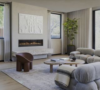 neutral living room with grey vintage area rug and grey sofa by Ryan Saghian