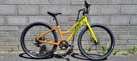 A pack shot of a bright yellow and orange bicycle with a step through frame