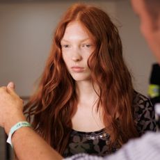 Redhead model getting her hair touched up backstage at Roberto Cavalli spring 2025 show 