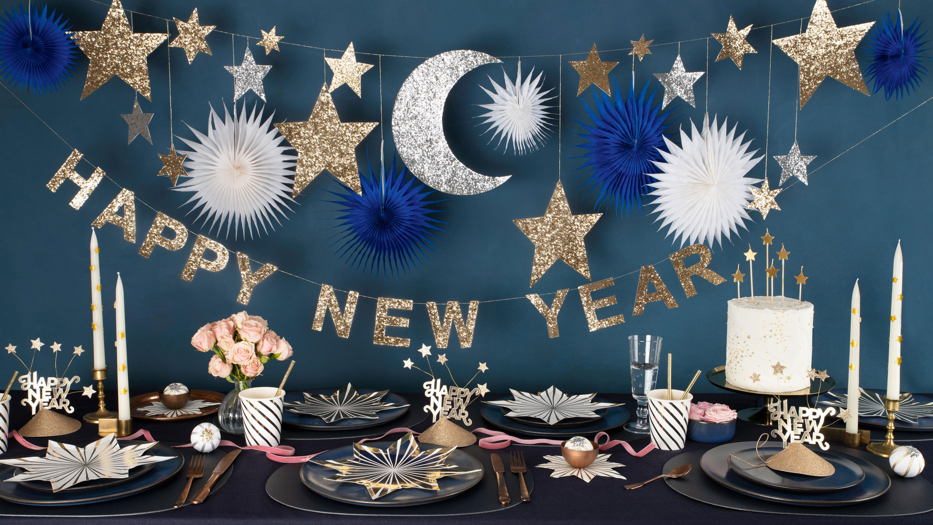Blue wall with gold, silver and blue bunting spelling out 'Happy New Year'