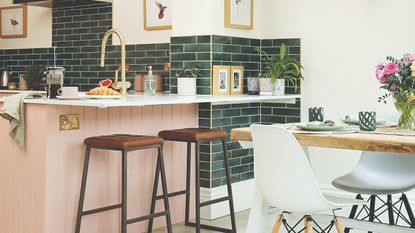 A dining area connected to a kitchen with a bar and stools