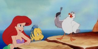 Ariel, Flounder, and Scuttle looking at a fork in The Little Mermaid
