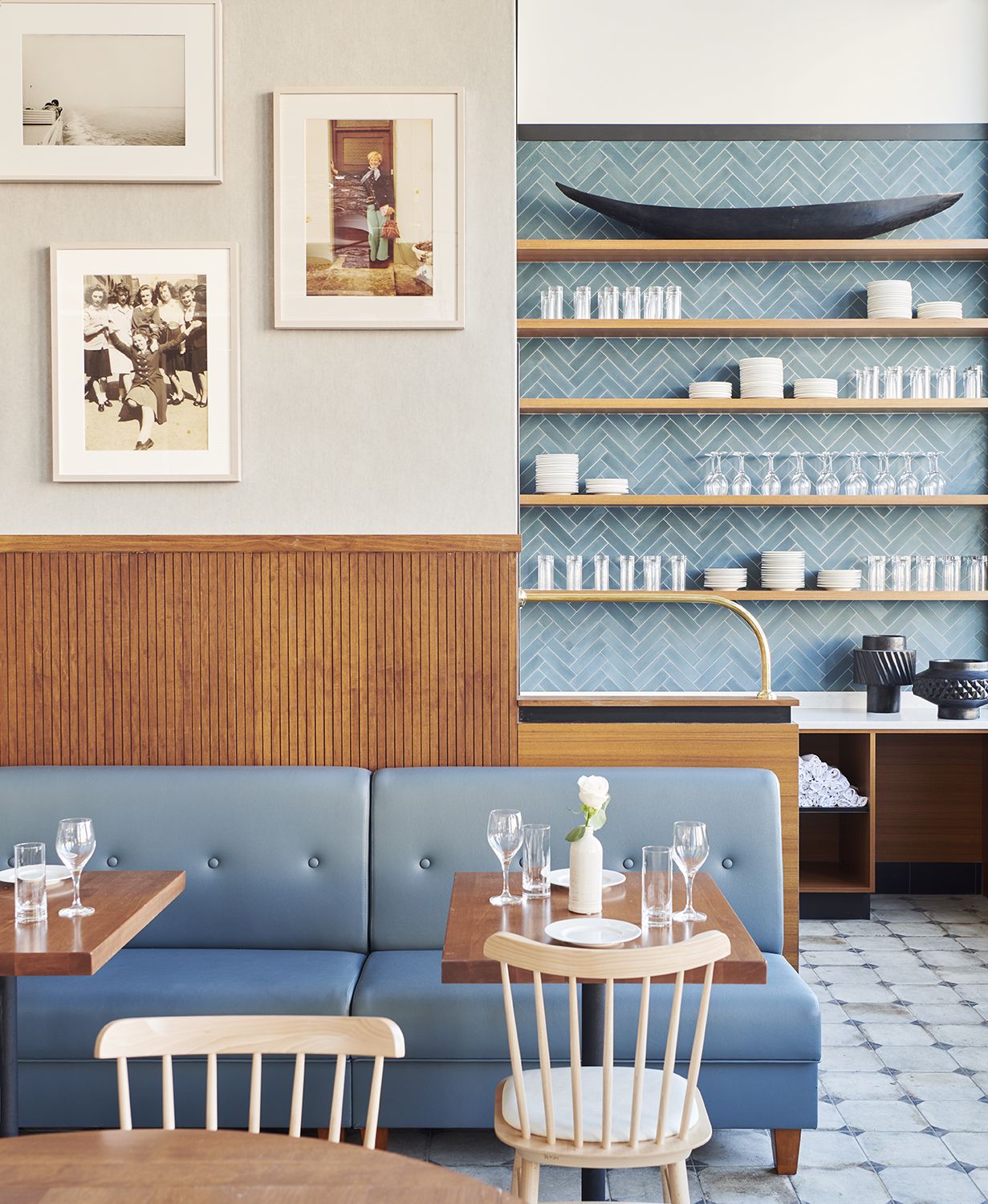 A blue and wood-shaded hotel restaurant with tiled floors and walls exudes a Mediterranean, coastal vibe.