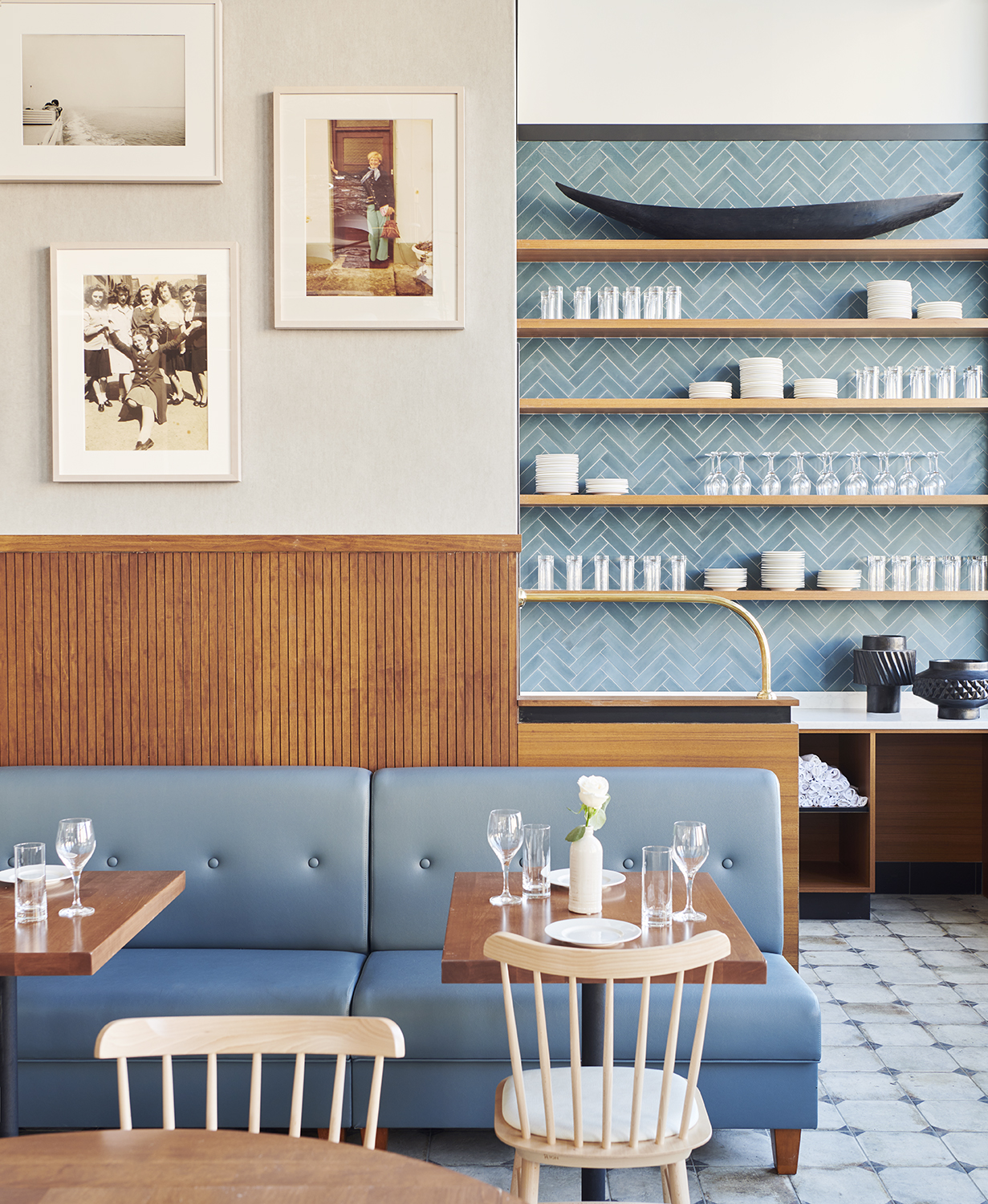 A blue and wood-shaded hotel restaurant with tiled floors and walls exudes a Mediterranean, coastal vibe.