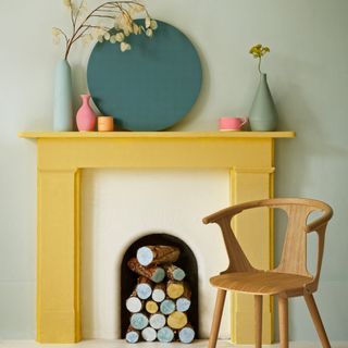 painted fireplace with wooden chair and plant on vase