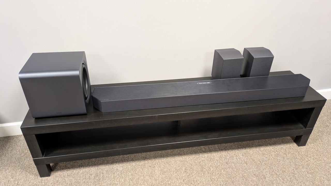 Samsung HW-Q990F soundbar, subwoofer and speakers on a dark bench