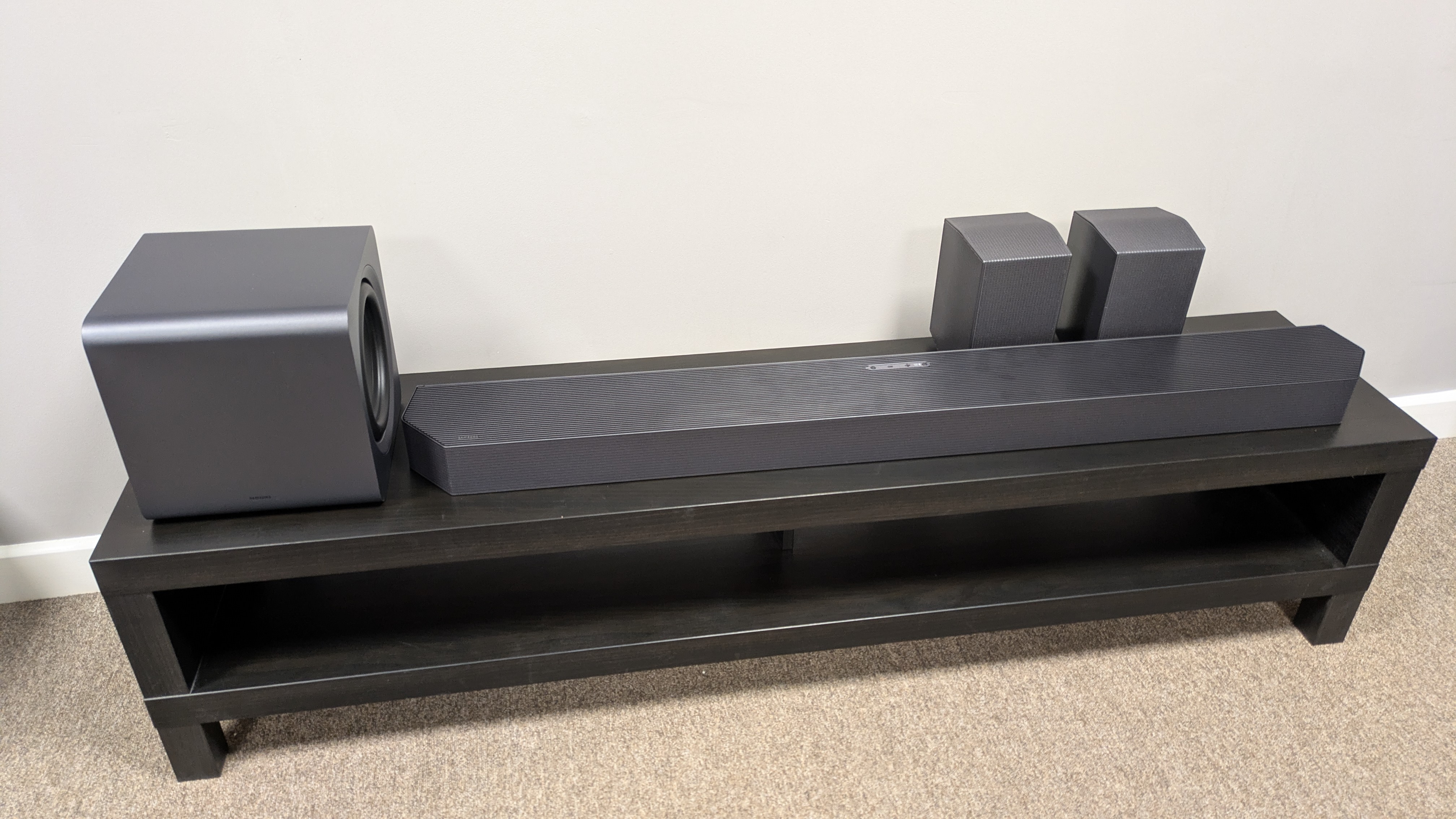 Samsung HW-Q990F soundbar, subwoofer and speakers on a dark bench