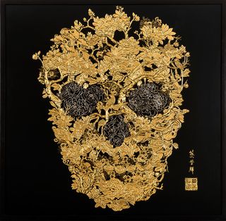 golden floral human skull art work on a black background