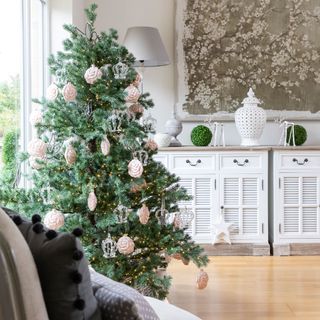 living room with christmas tree and white cupboard