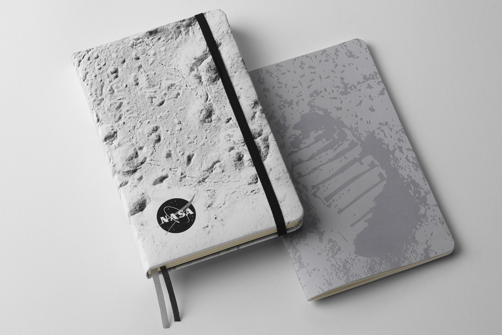NASA-inspired Limited Edition Notebooks from Moleskine. Left: Hardcover notebook with close up of the moon's surface on the front cover. Right: Softcover with Neil Armstrong's footprint on the moon on the front cover.